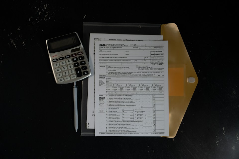 A calculator and financial paperwork on a dark desk